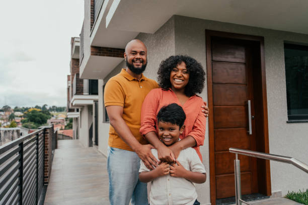 Portrait of a happy family in front of their new home